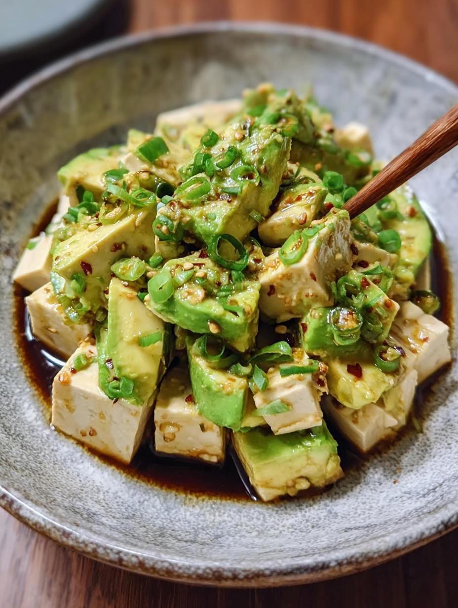 Astonishing Tofu Avocado Salad with fresh herbs and a zesty dressing, beautifully arranged on a white plate for a no-cook meal.